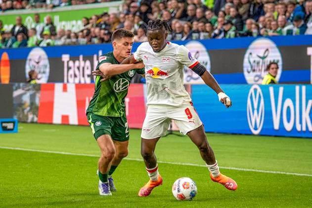Deutschland: Fussball 1. Bundesliga, 6. Spieltag 2025 2026, VfL Wolfsburg-RB Leipzig am 27.09.2025 in Wolfsburg (Volkswagen-Arena): Johan Bakayoko (RB Leipzig 9) und Joakim Maehle (VfL Wolfsburg 21) im Zweikampf Copyright: xSvenxHeidmannx