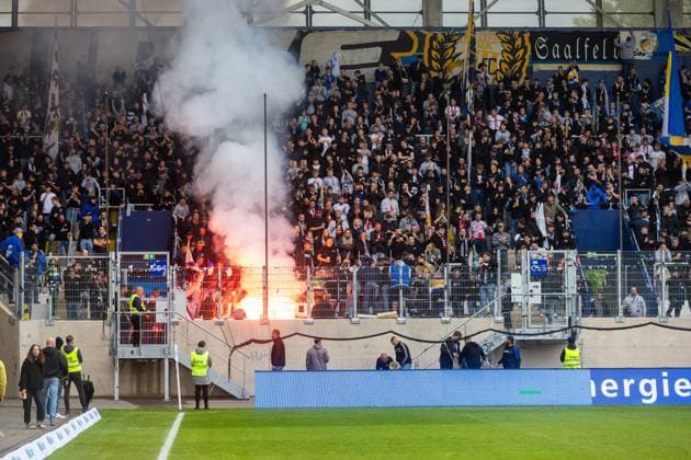 Jena , 270925, Fussball Regionalliga , FC Carl Zeiss Jena gegen Chemnitzer FC im Bild: Fans Ultras Jena Horda provozieren Spielunterbrechung indem sie zwei Fluchttore mit Transparenten und Fanen im Block versprerren