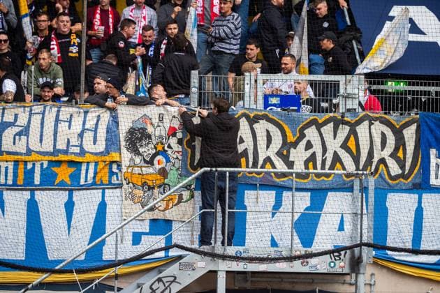 Jena , 270925, Fussball Regionalliga , FC Carl Zeiss Jena gegen Chemnitzer FC im Bild: Fans Ultras Jena Horda provozieren Spielunterbrechung indem sie zwei Fluchttore mit Transparenten und Fanen im Block versprerren