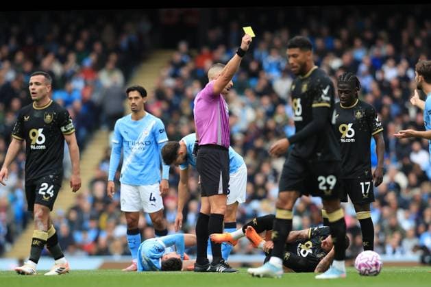 27th September 2025; Etihad Stadium, Manchester, England; Premier League Football, Manchester City versus Burnley; referee Robert Jones shows a yellow card to Kyle Walker of Burnley for a foul on Phil Foden of Manchester City  DavidxBlunsden