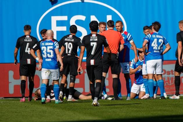 Schiedsrichter Justin Hasmann hat gerade dem im Hintergrund knieenden Ahmet Gürleyen (Rostock) eine Rote Karte Platzverweis gezeigt - links Florian Carstens (Rostock) und Franz Pfanne (Rostock) beim Schiedsrichtert; GER, FC Hansa Rostock vs. TSV Havelse, Fußball, Männer, 3. Liga, 08.Spieltag, Spielzeit 2025 2026, 27.09.2025 Rostock Ostseestadion Mecklenburg - Vorpommern Deutschland