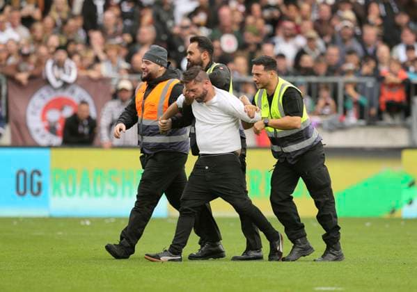 Foto : immer wieder die berühmte Nummer : ein Flitzer aus dem Publikum stürmt das Spielfeld und wird von 3 Sicherheitskräften Ordnern) überwältigt Fussball 1. Bundesliga , 5. Spieltag am Sa. 27.09.2025 FC St. Pauli - Bayer 04 Leverkusen 1 - 2