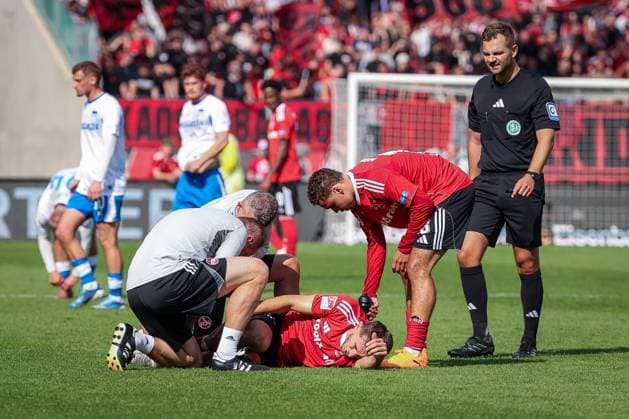 Adam Markhiyev 6 (1FC Nuernberg) wird behandelt nach einem Zweikampf, muss verletzt das Feld verlassen, mit Referee Schiedsrichter Marc Philip Eckermann, 1. FC Nuernberg vs. Hertha BSC Berlin, DFL, 2. Bundesliga, Saison 2025 2026, Max-Morlock-Stadion, Hinrunde, 7. Spieltag, 28.09.2025 DFB regulations prohibit any use of photographs as image sequences and or quasi-video Nuernberg Bayern Deutschland