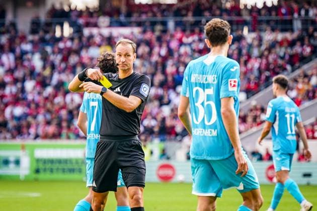 Deutschland: Fussball Bundesliga 2025 26, 5. Spieltag - SC Freiburg vs TSG Hoffenheim - Europa-Park-Stadion (Freiburg): Schiedsrichter Bastian Dankert (Rostock) zeigt Arthur Chaves (TSG Hoffenheim, 35) Gelbe Karte Copyright: xJOERANxSTEINSIEKx