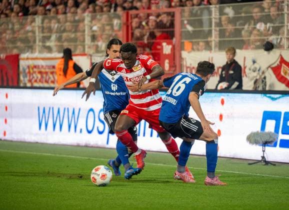 Fußball, Herren, Saison 2025 2026, 1. Bundesliga (5. Spieltag), 1. FC Union Berlin - Hamburger SV, v. l. Rayan Philippe (Hamburger SV), Derrick Köhn (1. FC Union Berlin), Giorgi Gocholeishvili (Hamburger SV), 28.09.2025, Copyright: xMatthiasxKochx