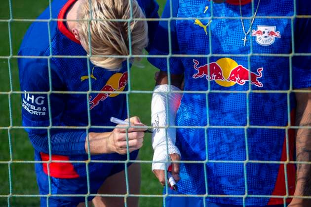 GER, Leipzig, Fußball, Bundesliga, oeffentliches Training, RB Leipzig im Bild v.l.: Conrad Harder (RB Leipzig 11), unterschreibt auf Gipsarm von Antonio Nusa (RB Leipzig 07), 30.09.2025, RB Leipzig Training Akademie Cottaweg Leipzig DFL DFB REGULATIONS PROHIBIT ANY USE OF PHOTOGRAPHS AS IMAGE SEQUENCES AND OR QUASI-VIDEO, Copyright: HMBxMedia PaulxFritz