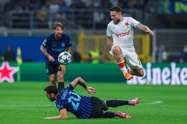 Vasil Kusej of SK Slavia Praha competes for the ball with Hakan Calhanoglu of FC Internazionale during UEFA Champions League 2025 26 League Phase - Matchday2 football match between FC Internazionale and SK Slavia Praha at San Siro Stadium  Copyright: xFabrizioxCarabelli IPAxSportx xipa-agency.netx xx IPA_65973920 IPA_Agency_IPA65973920