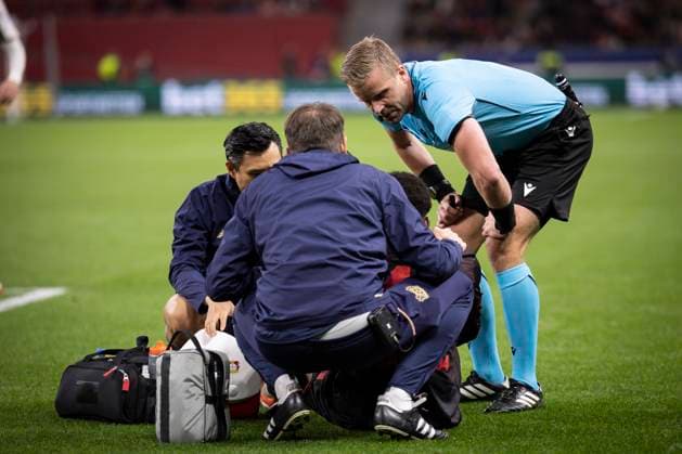 UEFA Champions League, Bayer 04 Leverkusen - PSV Eindhoven; 01.10.2025 Schiedsrichter Glenn Nyberg (Schweden) ist beim Team um den verletzten Axel Tape (Bayer 04 Leverkusen, 16); UEFA Champions League, Bayer 04 Leverkusen - PSV Eindhoven, Spieltag 2 am 01.10.2025 in der BayArena in Leverkusen. Copyright: xBEAUTIFULxSPORTS AxelxKohringx