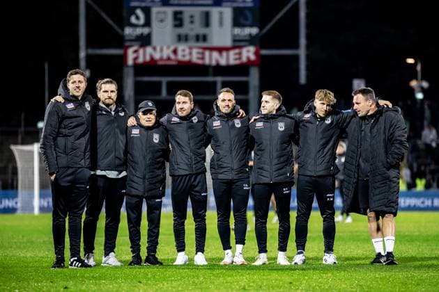 Fussball, Saison 2025 2026, 3. Liga, Donaustadion Ulm, 9. Spieltag, SSV Ulm 1846 Fußball - 1. FC Schweinfurt 05, 01.10.2025 01.10.2025, Fussball, Saison 2025 2026, 3. Liga, Donaustadion Ulm, 9. Spieltag, SSV Ulm 1846 Fußball - 1. FC Schweinfurt 05, Jubel Emotionen Freude nach dem 5:1 Heimsieg der Spatzen. Das Trainerteam stellt sich in zweite Reihe v.l. Co-Trainer Max Kohlenberg (SSV Ulm 1846 Fußball), Mannschaftsarzt Dr. Alexander Henze (SSV Ulm 1846 Fußball), Betreuer Emilio Tancredi (SSV Ulm 1846 Fußball), Interimstrainer Moritz Glasbrenner (SSV Ulm 1846 Fußball), Atlethiktrainer Tim Gulde (SSV Ulm 1846 Fußball), Physio Raimund Felber (SSV Ulm 1846 Fußball), Analyst Patrick Waltenberger (SSV Ulm 1846 Fußball), Torwarttrainer Holger Betz (SSV Ulm 1846 Fußball) Foto: Lucca Fundel Ulm Donaustadion Baden-Württemberg Deutschland
