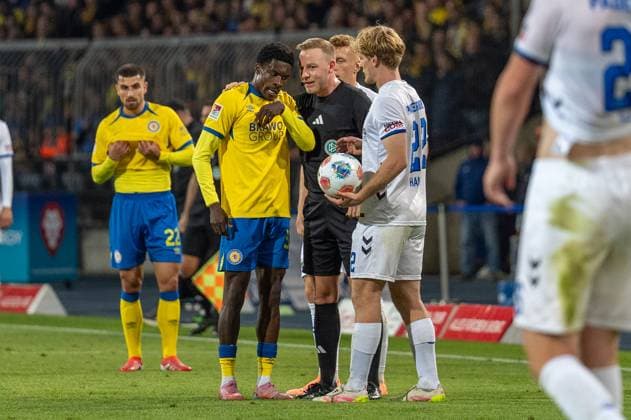 Deutschland: Fussball 2. Liga, 8. Spieltag 2025 2026, Eintracht Braunschweig-SC Paderborn 07 am 03.10. in Braunschweig (Eintracht-Stadion): Schiedsrichter Lars Erbst im Gespräch mit Christian Joe Conteh (Eintracht Braunschweig 32)