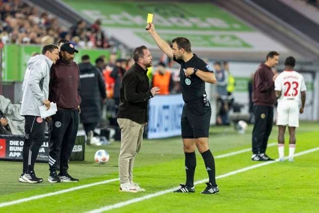2. Fussball Bundesliga, Fortuna Düsseldorf - 1. FC Nürnberg; 03.10.2025 Schiedsrichter Wolfgang Haslberger zeigt Christian Weber (Sportdirektor Fortuna Düsseldorf) die gelbe Karte. 2. Fußball Bundesliga, Fortuna Düsseldorf - 1. FC Nürnberg, 8. Spieltag, am 03.10.2025, Merkur Spiel-Arena, Düsseldorf. DFL regulations prohibit any use of photographs as image sequences and or quasi-video