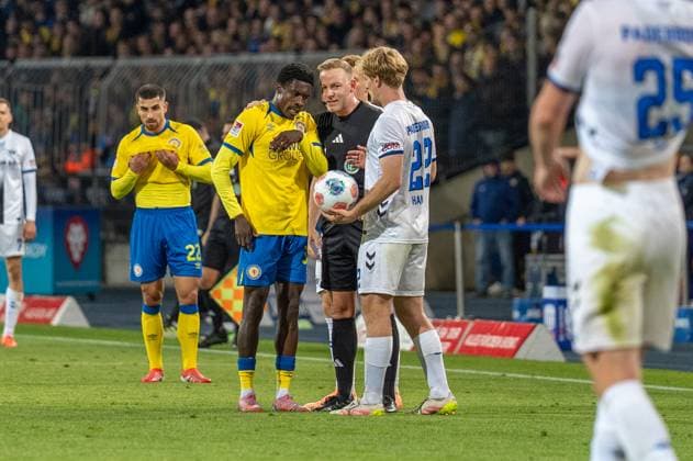 Deutschland: Fussball 2. Liga, 8. Spieltag 2025 2026, Eintracht Braunschweig - SC Paderborn 07 am 03.10. in Braunschweig (Eintracht-Stadion): Schiedsrichter Lars Erbst im Gespräch mit Christian Joe Conteh (Eintracht Braunschweig 32)
