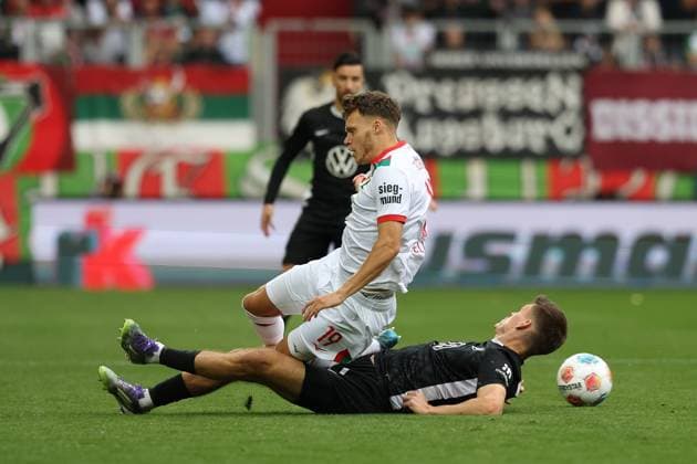 im Zweikampf, Aktion, mit Robin Fellhauer 19 (FC Augsburg), Joakim Maehle 21 (VfL Wolfsburg), FC Augsburg vs. VfL Wolfsburg, Fussball, 1. Bundesliga, 6. Spieltag, 04.10.2025 DFB regulations prohibit any use of photographs as image sequences and or quasi-video Augsburg Bayern Deutschland