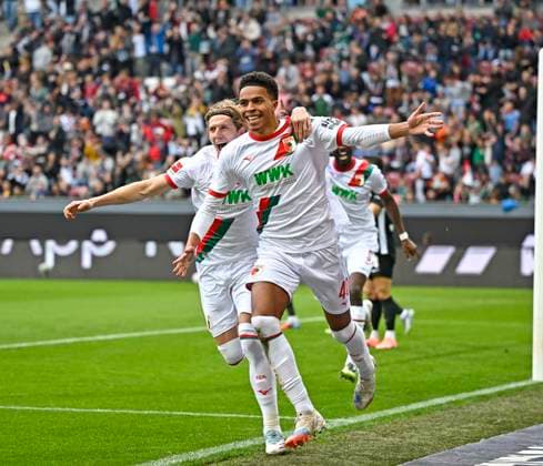 04.10.2025, Fussball 1. Bundesliga 2025 2026, 6.Spieltag, FC Augsburg - VfL Wolfsburg, in der WWK-Arena Augsburg. v.l. Kristjan Jakic (FC Augsburg) und Noahkai Dominic Banks (FC Augsburg) jubeln