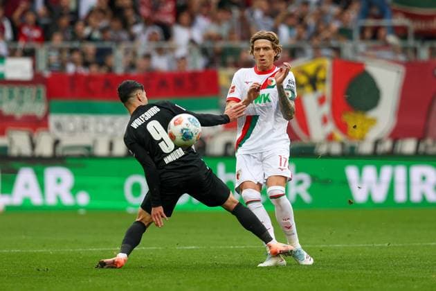 im Zweikampf, Aktion, mit Mohamed Amoura 9 (VfL Wolfsburg), Kristijan Jakic 17 (FC Augsburg), FC Augsburg vs. VfL Wolfsburg, Fussball, 1. Bundesliga, 6. Spieltag, 04.10.2025 DFB regulations prohibit any use of photographs as image sequences and or quasi-video Augsburg Bayern Deutschland