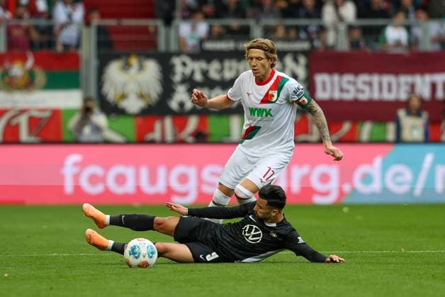im Zweikampf, Aktion, mit Kristijan Jakic 17 (FC Augsburg), Mohamed Amoura 9 (VfL Wolfsburg), FC Augsburg vs. VfL Wolfsburg, Fussball, 1. Bundesliga, 6. Spieltag, 04.10.2025 DFB regulations prohibit any use of photographs as image sequences and or quasi-video Augsburg Bayern Deutschland