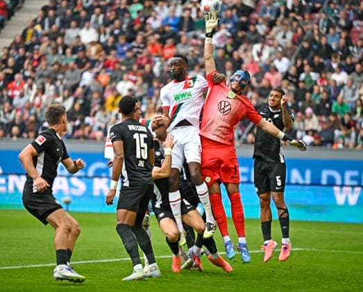 04.10.2025, Fussball 1. Bundesliga 2025 2026, 6.Spieltag, FC Augsburg - VfL Wolfsburg, in der WWK-Arena Augsburg. Iris Chrislain Aurel Matisma (FC Augsburg) gegen Torwart Kamil Grabara (Wolfsburg)