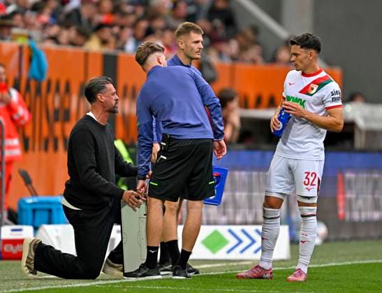 04.10.2025, Fussball 1. Bundesliga 2025 2026, 6.Spieltag, FC Augsburg - VfL Wolfsburg, in der WWK-Arena Augsburg. v.l. Trainer Sandro Wagner (FC Augsburg) mit Fabian Rieder (FC Augsburg) und der Taktiktafel.