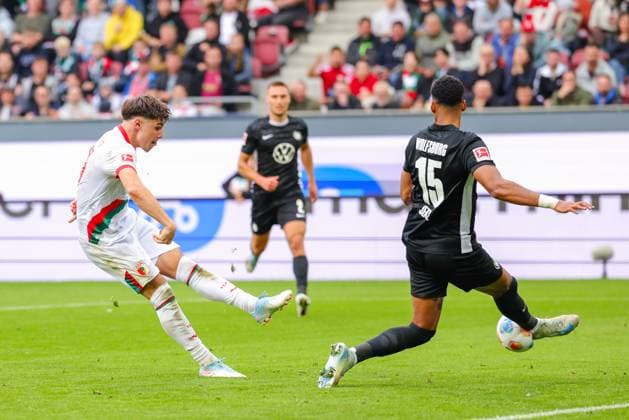 Mert Kömür (36, FC Augsburg) und Moritz Jenz (15, VfL Wolfsburg) beim Spiel zwischen FC Augsburg v VfL Wolfsburg, Fußball, Herren, Bundesliga, 2025 2026, 6.Spieltag am 04.10.2025 in Augsburg, WWK-Arena. DFL and DFB regulations prohibit any use of photographs as image sequences and or quasi-video. Bayern Deutschland