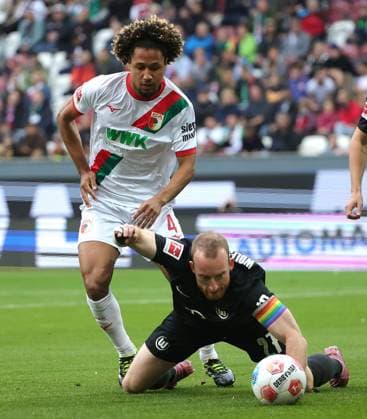 04.10.2025, 1. Bundesliga , FC Augsburg vs VfL Wolfsburg, WWK Arena Augsburg , Fussball, im Bild: Han-Noah Massengo (FC Augsburg) fault Maximilian Arnold (VfL Wolfsburg)