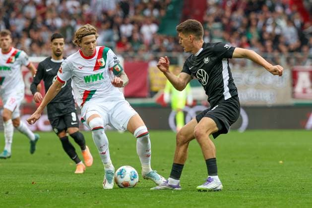 im Zweikampf, Aktion, mit Kristijan Jakic 17 (FC Augsburg), Joakim Maehle 21 (VfL Wolfsburg), FC Augsburg vs. VfL Wolfsburg, Fussball, 1. Bundesliga, 6. Spieltag, 04.10.2025 DFB regulations prohibit any use of photographs as image sequences and or quasi-video Augsburg Bayern Deutschland