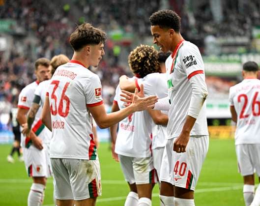 04.10.2025, Fussball 1. Bundesliga 2025 2026, 6.Spieltag, FC Augsburg - VfL Wolfsburg, in der WWK-Arena Augsburg. Mert Kömür (FC Augsburg) jubelt mit Noahkai Dominic Banks (FC Augsburg)