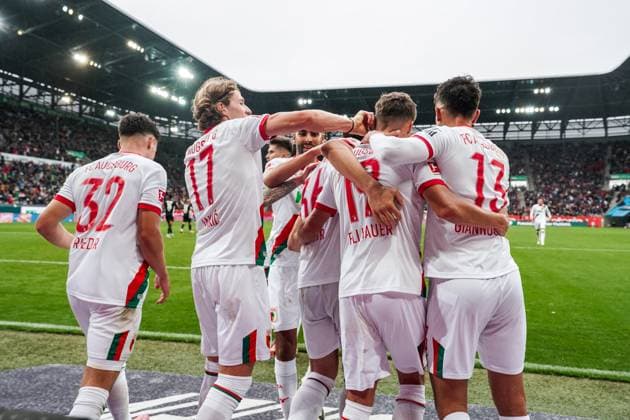 1. Bundesliga 2025 2026 - 6. Spieltag 04.10.2025 - FC Augsburg vs.VfL Wolfsburg - WWK Arena (Augsburg, Deutschland); FC Augsburg Spieler jubeln nach dem Tor zum 3:1 Copyright: xLukaxKolanovicx