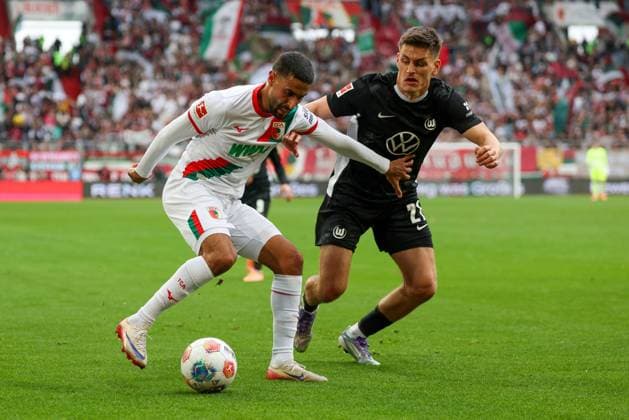 im Zweikampf, Aktion, mit Elias Saad 26 (FC Augsburg), Joakim Maehle 21 (VfL Wolfsburg), FC Augsburg vs. VfL Wolfsburg, Fussball, 1. Bundesliga, 6. Spieltag, 04.10.2025 DFB regulations prohibit any use of photographs as image sequences and or quasi-video Augsburg Bayern Deutschland