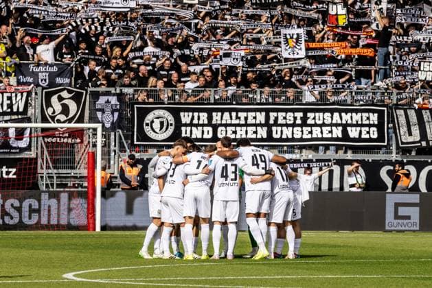 Fussball, Saison 2025 2026, 3. Liga, Audi-Sportpark Ingolstadt, 10. Spieltag, FC Ingolstadt - SSV Ulm 1846 Fußball, 04.10.2025 04.10.2025, Fussball, Saison 2025 2026, 3. Liga, Audi-Sportpark Ingolstadt, 10. Spieltag, FC Ingolstadt - SSV Ulm 1846 Fußball, Teamkreis Team Mannschaftskreis Mannschaft SSV Ulm 1846 Fußball vor den rund 1400 mitgereisten Fans des SSV Ulm D-Block im Fanblock Gästeblock des Audi-Parks Foto: Lucca Fundel Ingolstadt Audi-Sportpark Bayern Deutschland