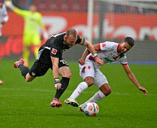 04.10.2025, Fussball 1. Bundesliga 2025 2026, 6.Spieltag, FC Augsburg - VfL Wolfsburg, in der WWK-Arena Augsburg. v.l. Maximilian Arnold (Wolfsburg) gegen Elias Saad (FC Augsburg)