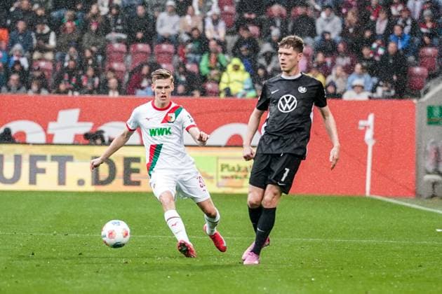 1. Bundesliga 2025 2026 - 6. Spieltag 04.10.2025 - FC Augsburg vs.VfL Wolfsburg - WWK Arena (Augsburg, Deutschland); Anton Kade (FC Augsburg), Andreas Skov Olsen (VfL Wolfsburg) Copyright: xLukaxKolanovicx