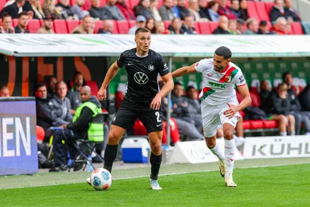 Kilian Fischer (2, VfL Wolfsburg) und Elias Saad (26, FC Augsburg) beim Spiel zwischen FC Augsburg v VfL Wolfsburg, Fußball, Herren, Bundesliga, 2025 2026, 6.Spieltag am 04.10.2025 in Augsburg, WWK-Arena. DFL and DFB regulations prohibit any use of photographs as image sequences and or quasi-video. Bayern Deutschland