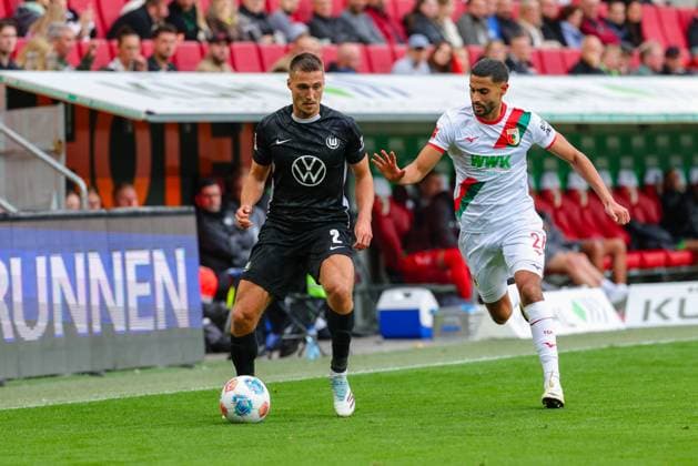 Kilian Fischer (2, VfL Wolfsburg) und Elias Saad (26, FC Augsburg) beim Spiel zwischen FC Augsburg v VfL Wolfsburg, Fußball, Herren, Bundesliga, 2025 2026, 6.Spieltag am 04.10.2025 in Augsburg, WWK-Arena. DFL and DFB regulations prohibit any use of photographs as image sequences and or quasi-video. Bayern Deutschland