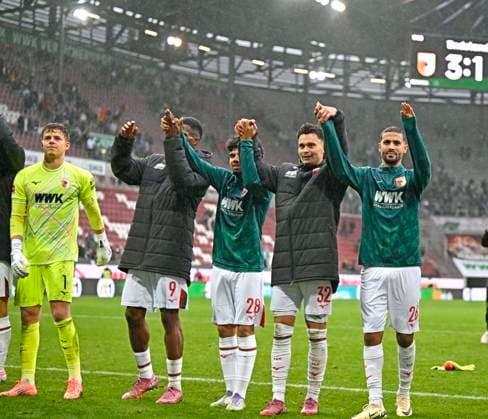 04.10.2025, Fussball 1. Bundesliga 2025 2026, 6.Spieltag, FC Augsburg - VfL Wolfsburg, in der WWK-Arena Augsburg. LaOla der Augsburger Spieler v.l. Torwart Finn Dahmen (FC Augsburg), Samuel Emmanuel Essende Mbongu (FC Augsburg), Andre Hahn (FC Augsburg), Fabian Rieder (FC Augsburg) und Elias Saad (FC Augsburg)