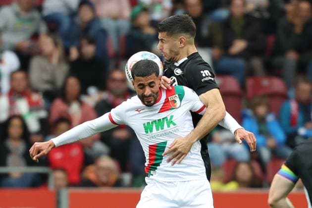 im Zweikampf, Aktion, mit Elias Saad 26 (FC Augsburg), FC Augsburg vs. VfL Wolfsburg, Fussball, 1. Bundesliga, 6. Spieltag, 04.10.2025 DFB regulations prohibit any use of photographs as image sequences and or quasi-video Augsburg Bayern Deutschland
