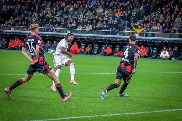 Serge Gnabry 7 (FC Bayern Muenchen) schiesst aufs Tor, Hugo Larsson 16 (Eintracht Frankfurt) und Robin Koch 4 (Eintracht Frankfurt) koennen es nicht verhindern, Eintracht Frankfurt vs. FC Bayern Muenchen, DFL, Bundesliga, Saison 2025 2026, Deutsche Bank Park, Hinrunde, 6. Spieltag, 04.10.2025 DFB regulations prohibit any use of photographs as image sequences and or quasi-video Frankfurt Hessen Deutschland