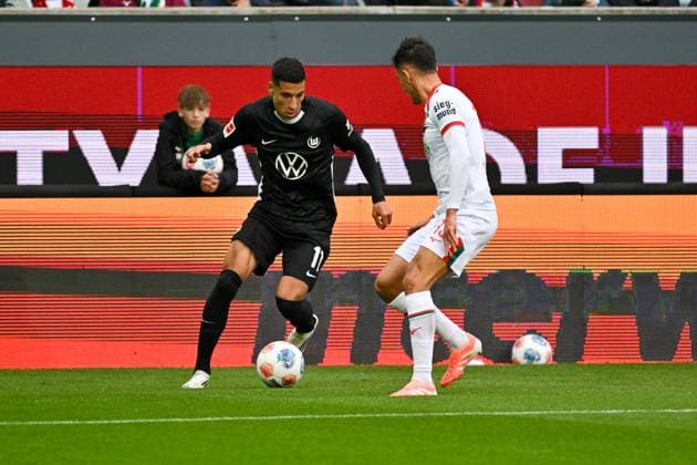 GER, Bayern, Augsburg, Fussball, FC Augsburg - VfL Wolfsburg, in der WWK Arena, Augsburg, 6. Spieltag, 04.10.25, v.l. Adam Daghim (VfL Wolfsburg, 11), Dimitrios Giannoulis (FC Augsburg, 13), im Zweikampf DFL DFB regulations prohibit any use of photographs as image sequences and or quasi-video, Copyright: HMB-Media MichaelxNibel