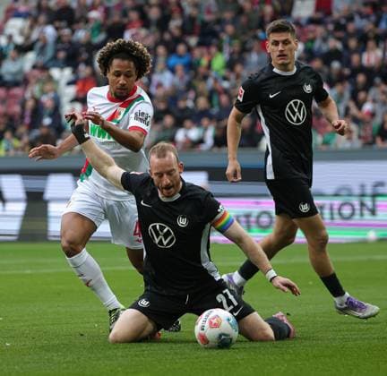 04.10.2025, 1. Bundesliga , FC Augsburg vs VfL Wolfsburg, WWK Arena Augsburg , Fussball, im Bild: Han-Noah Massengo (FC Augsburg) fault Maximilian Arnold (VfL Wolfsburg), Joakim Maehle (VfL Wolfsburg) schaut zu