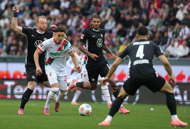 04.10.2025, 1. Bundesliga , FC Augsburg vs VfL Wolfsburg, WWK Arena Augsburg , Fussball, im Bild: Maximilian Arnold (VfL Wolfsburg), Fabian Rieder (FC Augsburg), Vini Souza (VfL Wolfsburg), Konstantinos Koulierakis (VfL Wolfsburg)