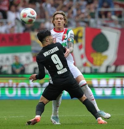 04.10.2025, 1. Bundesliga , FC Augsburg vs VfL Wolfsburg, WWK Arena Augsburg , Fussball, im Bild: Mohamed Amoura (VfL Wolfsburg) vs Kristijan Jakic (FC Augsburg)