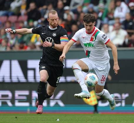 04.10.2025, 1. Bundesliga , FC Augsburg vs VfL Wolfsburg, WWK Arena Augsburg , Fussball, im Bild: Maximilian Arnold (VfL Wolfsburg) vs Mert Koemuer (FC Augsburg)