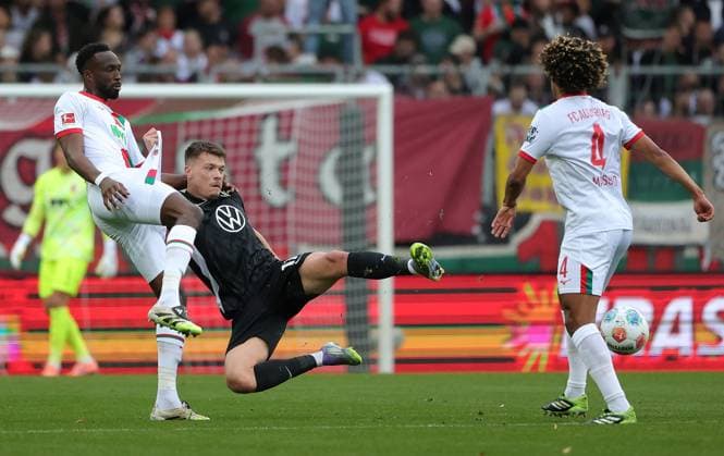 04.10.2025, 1. Bundesliga , FC Augsburg vs VfL Wolfsburg, WWK Arena Augsburg , Fussball, im Bild: Chrislain Matsima (FC Augsburg) vs Dzenan Pejcinovic (VfL Wolfsburg), Han-Noah Massengo (FC Augsburg)