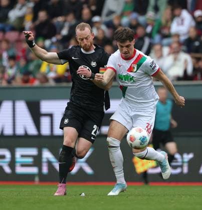 04.10.2025, 1. Bundesliga , FC Augsburg vs VfL Wolfsburg, WWK Arena Augsburg , Fussball, im Bild: Maximilian Arnold (VfL Wolfsburg) vs Mert Koemuer (FC Augsburg)