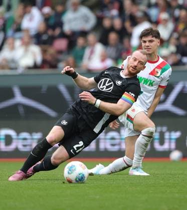 04.10.2025, 1. Bundesliga , FC Augsburg vs VfL Wolfsburg, WWK Arena Augsburg , Fussball, im Bild: Maximilian Arnold (VfL Wolfsburg) vs Mert Koemuer (FC Augsburg)