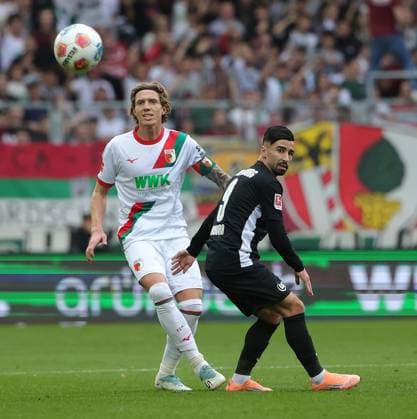 04.10.2025, 1. Bundesliga , FC Augsburg vs VfL Wolfsburg, WWK Arena Augsburg , Fussball, im Bild: Kristijan Jakic (FC Augsburg) vs Mohamed Amoura (VfL Wolfsburg)