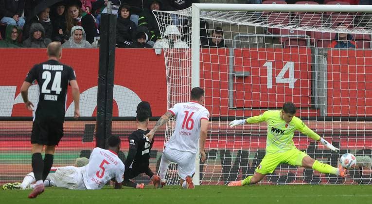 04.10.2025, 1. Bundesliga , FC Augsburg vs VfL Wolfsburg, WWK Arena Augsburg , Fussball, im Bild: Christian Eriksen (VfL Wolfsburg), Chrislain Matsima (FC Augsburg), Mohamed Amoura (VfL Wolfsburg), Cedric Zesiger (FC Augsburg), Finn Dahmen (FC Augsburg) rettet