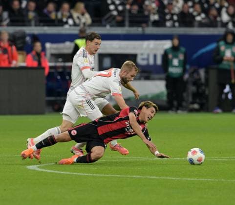 Konrad Laimer (li) fällt Ritsu. Doan (am Boden). Und Leon Goretzka (hi). fotografiert beim Fußball Bundesliga Spiel Eintracht Frankfurt gegen den FC Bayern München am 4.10.2025 in Frankfurt (DFL DFB REGULATIONS PROHIBIT ANY USE OF PHOTOGRAPHS as IMAGE SEQUENCES and or QUASI-VIDEO)