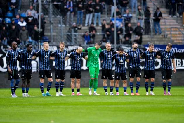 Die Spieler vom SV Waldhof Mannheim vor dem Anpfiff bei einer Schweigeminute für das verstorbene Ehrenmitglied und ehemalige Präsidiumsmitglied Manfred Göth (Männel), vor Spielbeginn, Schweigen, Trauer, Gedenken, Gedenkminute, im Andenken, Anteilnahme, Sprachlosigkeit, Aktion, Action, 04.10.2025, Mannheim (Deutschland), Fussball, 3. Liga, SV Waldhof Mannheim - VfL Osnabrück, DFB DFL REGULATIONS PROHIBIT ANY USE OF PHOTOGRAPHS AS IMAGE SEQUENCES AND OR QUASI-VIDEO.
