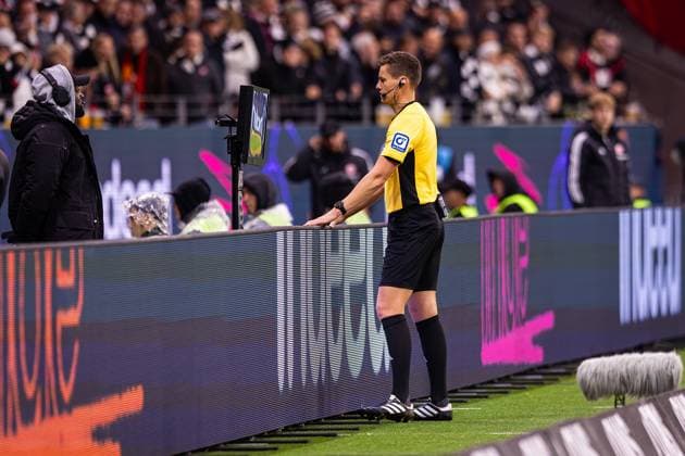 04.10.2025, xovx, Fußball Bundesliga, Eintracht Frankfurt - FC Bayern München Schiedsrichter Daniel Siebert (Berlin) schaut sich per Videobeweis die Szene des Handspiels vor dem Tor zum 1:1 an. (DFL DFB REGULATIONS PROHIBIT ANY USE OF PHOTOGRAPHS as IMAGE SEQUENCES and or QUASI-VIDEO) emspor Frankfurt am Main