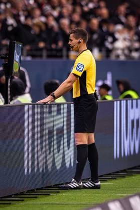 04.10.2025, xovx, Fußball Bundesliga, Eintracht Frankfurt - FC Bayern München Schiedsrichter Daniel Siebert (Berlin) schaut sich per Videobeweis die Szene des Handspiels vor dem Tor zum 1:1 an. (DFL DFB REGULATIONS PROHIBIT ANY USE OF PHOTOGRAPHS as IMAGE SEQUENCES and or QUASI-VIDEO) emspor Frankfurt am Main